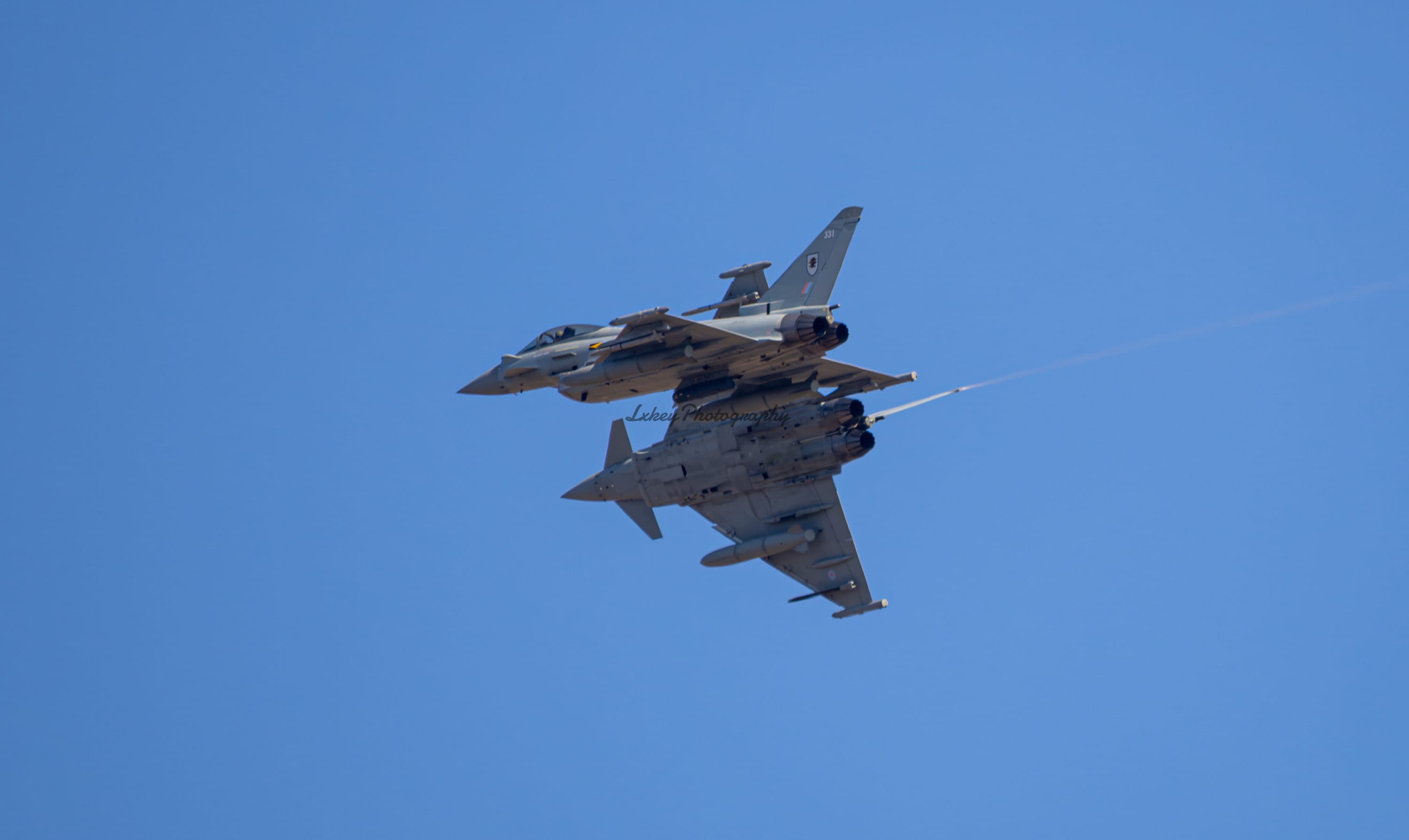 Pair of Royal Air Force Typhoons crossing in a banking break, led by 12 Squadron aircraft ZK331