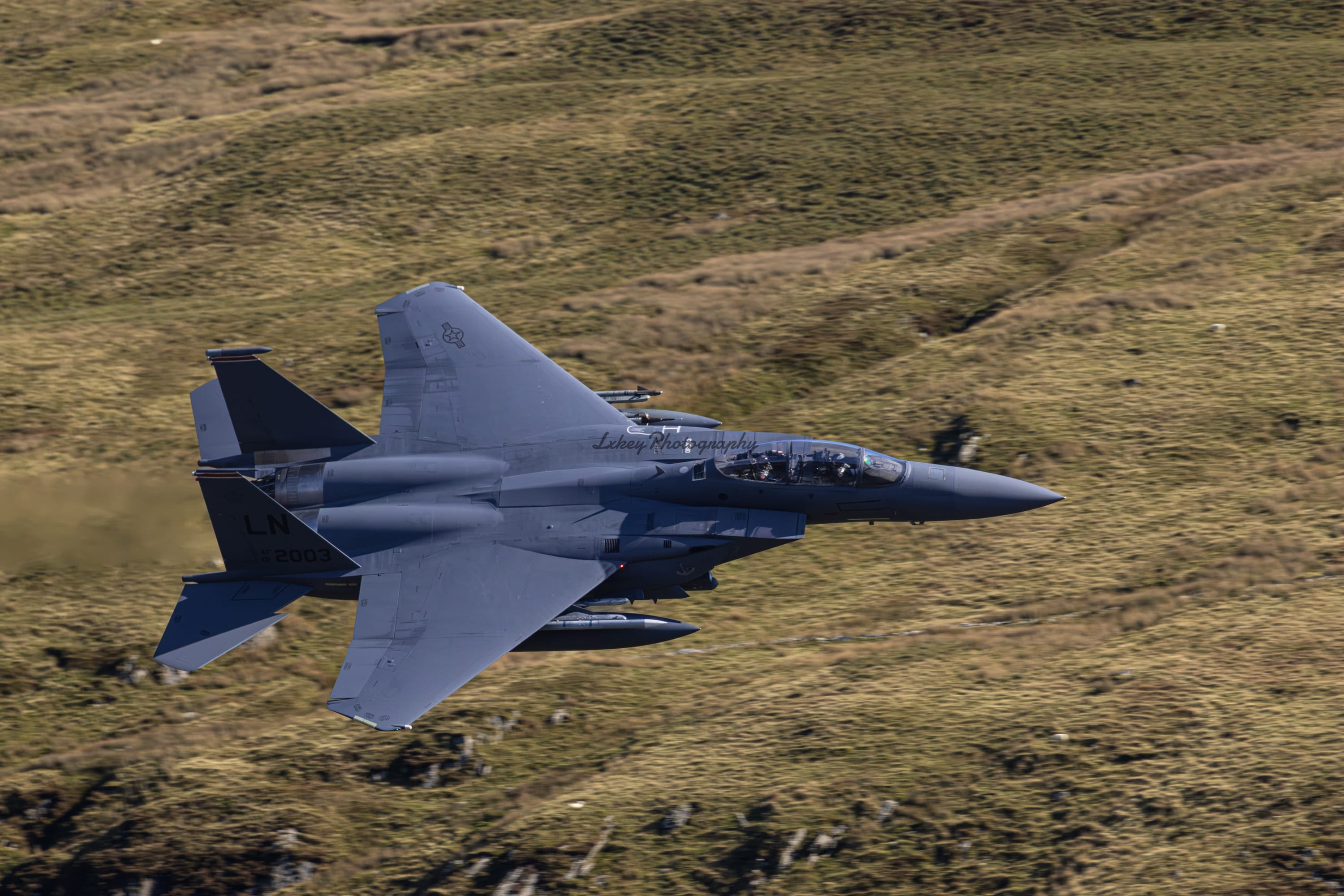 USAF F-15E Strike Eagle 01-2003 of the 494th Fighter Squadron banking low through the Mach Loop in Wales